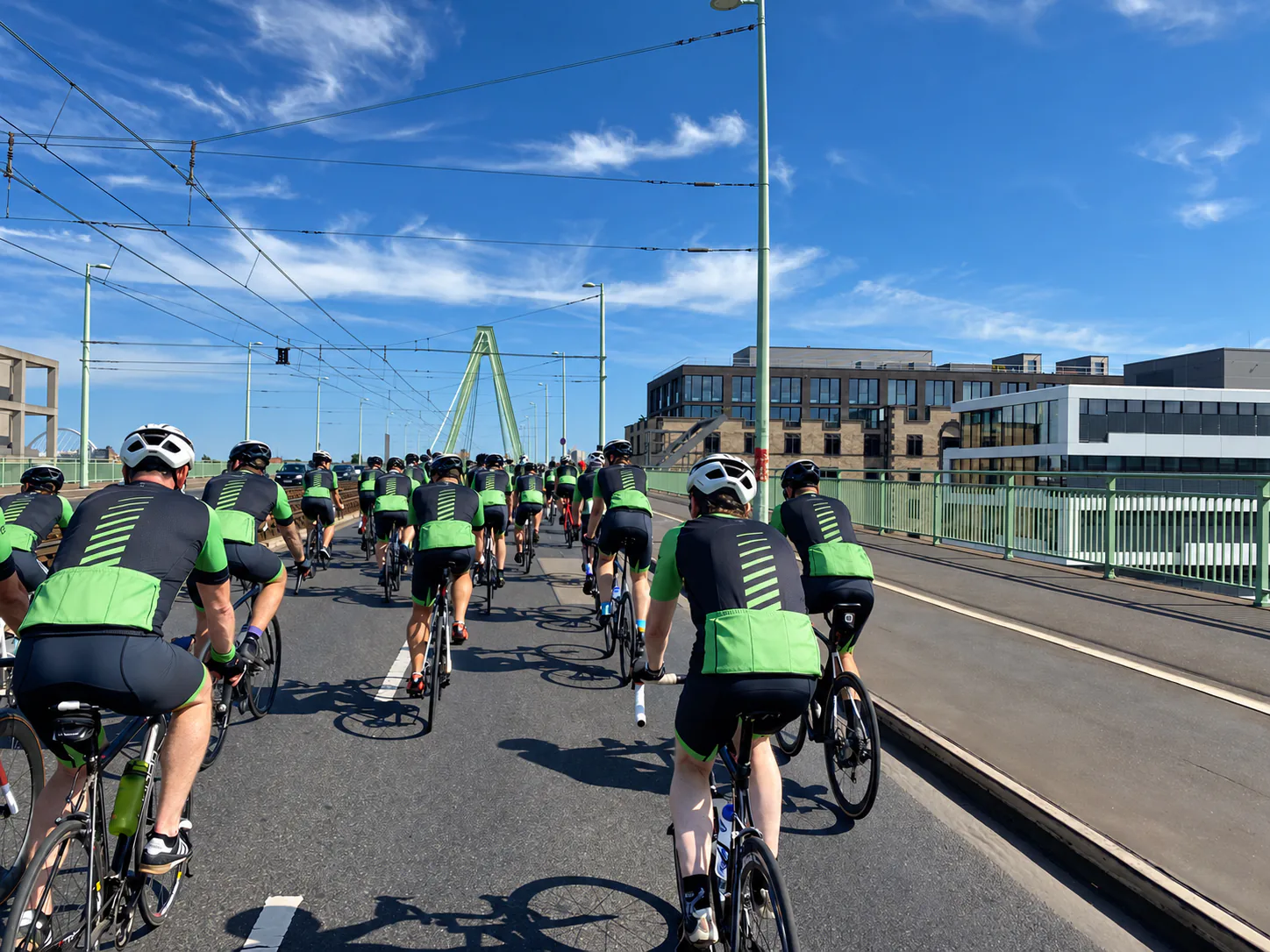 Rennradfahrer in einheitlichen Trikots bei einem Radrennen auf einer Stadtbrücke